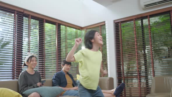 Happiness cheerful asian family dad mom and son funny dancing in living room