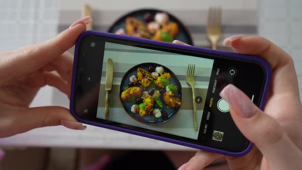 Girl take pictures of grilled peach salad with mozzarella, using smartphone alt