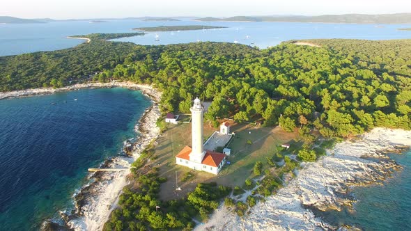Aerial view of lighthouse, Croatia on forested shore alt