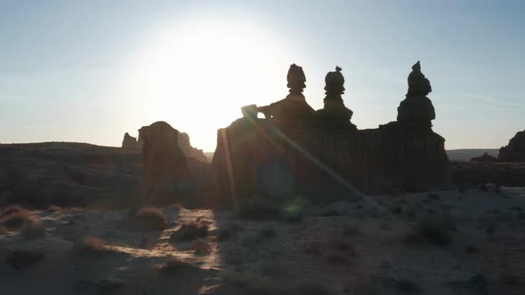 Cinematic Aerial of Goblin Valley Nature Park with Sun Shining Behind Red Spires alt