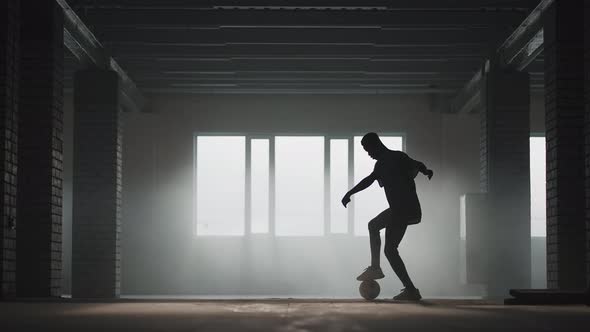 Africanamerican Soccer Player Practicing Kicks and Moves Inside Empty Covered Parking Garage alt