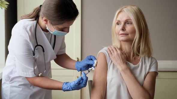 Professional Doctor or Nurse Giving Flu or COVID19 Injection to Patient alt