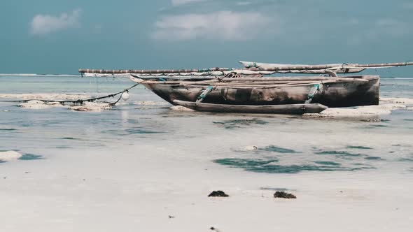 Old Dry African Fishing Rowboat Stranded in Sand on Beach at Low Tide Zanzibar alt