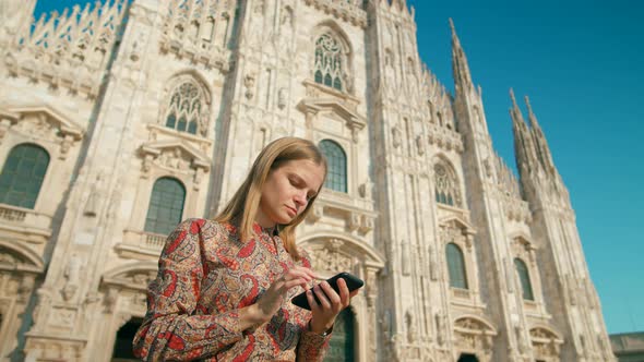 Woman Uses Smartphone App in Milan Italy Near Landmark Cathedral on Summer Day