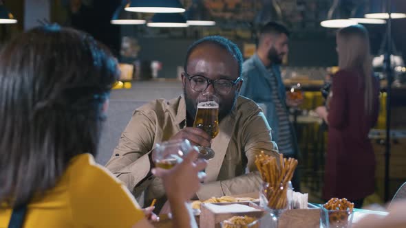 Smiling African American man sitting in bar with woman