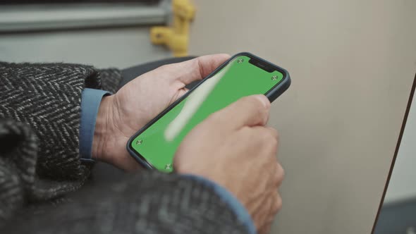 A man uses a smartphone on the bus. Green screen. Phone mockup. alt