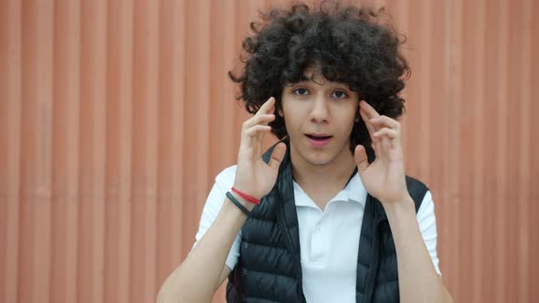 Slow Motion Portrait of Mixed Race Teenager Touching Head Feeling Headache Standing Outdoors alt