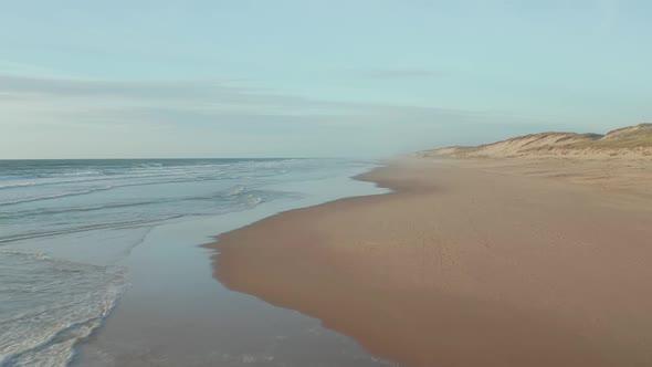 Empty Endless Beach with Dunes and Blue Ocean, Aerial High Angle Forward Into the Distance in alt