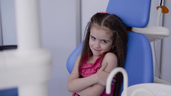 Portrait of Happy Little Girl Smiling at Camera in Dental Chair alt