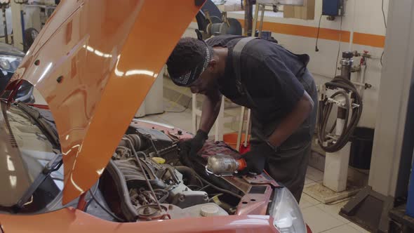 African American Mechanic Checking Car Parts in Auto Repair Shop alt