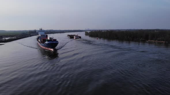 Container Ship Of Pachuca On The Oude Maas River With A View Of Green Woods In Netherlands. aerial alt