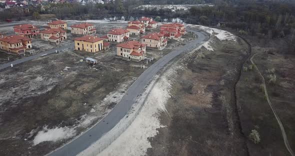 Drone Flying Over a Construction Site, Around Trees, a Lake and Sand