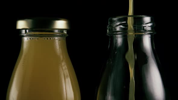 Two Bottles on a Black Background with Juice. 