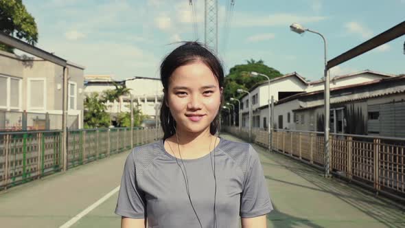 Attractive young Asian woman smiling looking at camera.