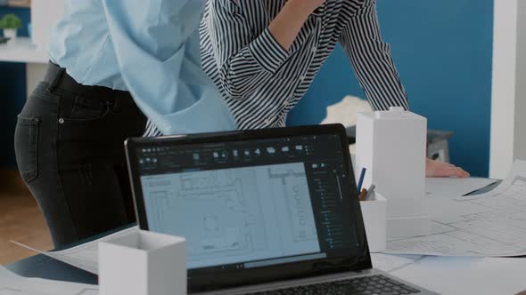 Close Up of Multi Ethnic Women Working Together to Design Construction Blueprints alt