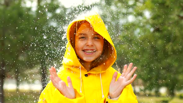 Smiling Teenage Girl Wearing Raincoat Outdoors in Rainy Day alt