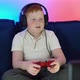 A Boy Gamer is Sitting on a Couch in Front of the Monitor Playing and Winning in Video Games on - VideoHive Item for Sale