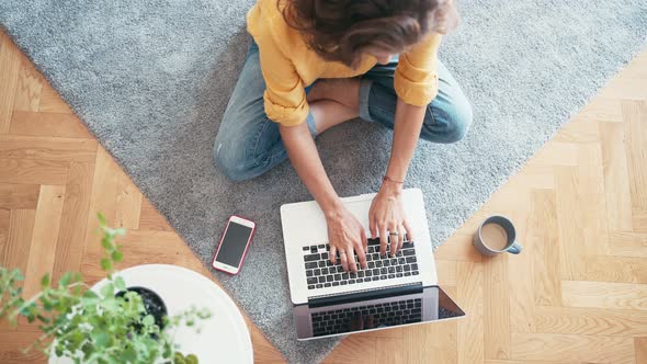 Top View Shot of a Young Woman Typing on Her Laptop alt