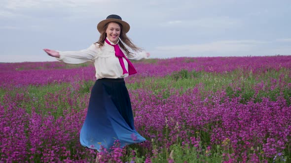 Girl in a Blue Dress with a White Blouse and a Straw Hat Walks Along alt