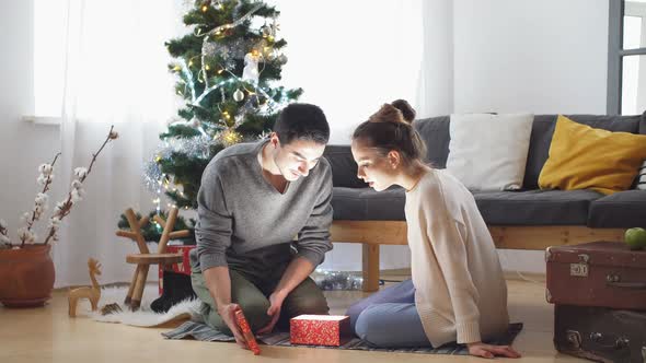 Romantic Couple Exchanging Christmas Gifts