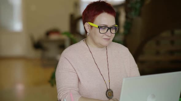 Middle Aged Woman with Glasses Typing Text on Laptop at Home Serious Focused alt