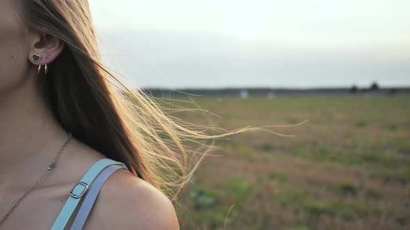 Long Hair of the Brownhaired Young Girl Scatter in the Wind in the Sunshine Rays of the Evening alt