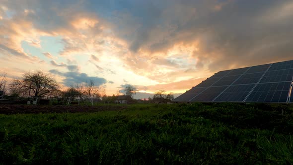 Golden sunlight touches the solar panels in the backyard of a country house.