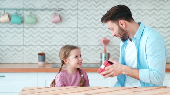 Little preschool girl giving gifts to her dad for father's day alt