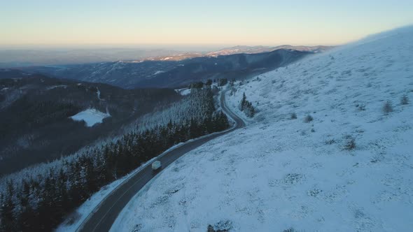 White Semitrailer Truck Fast Driving Toward on Slippery Winter Asphalt Mountain Highway alt