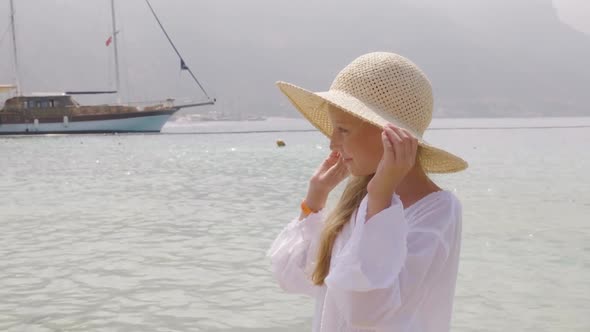 Portrait Girl Teenager in Straw Hat Watching on Sea and Ship Background alt