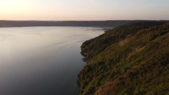 Aerial view of wide Dnister river and distant rocky hills in Bakota area, part of the National park,