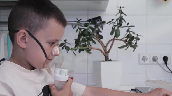 Boy breathing with an inhaler at home