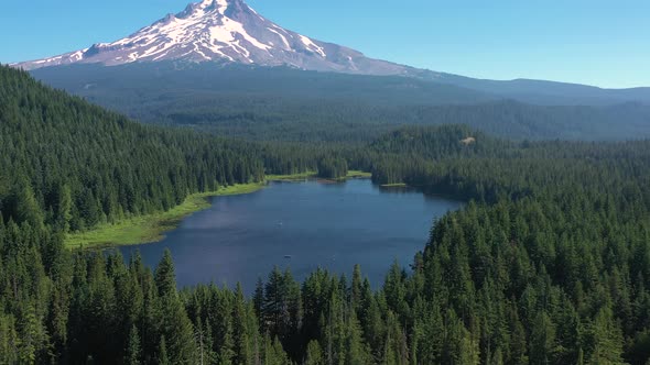 Beautiful reveal of Trillium Lake and the iconic Mount Hood covered in snow in summer. alt