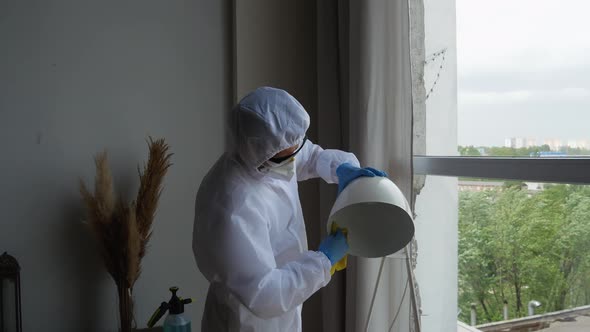 Men in virus protective suit making treatment from coronavirus, preventive measures