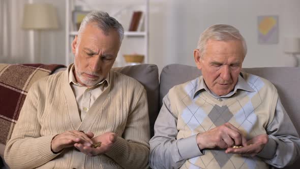 Elderly Men Counting Coins and Looking at Camera, Low Social Payment, Poverty alt