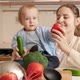 Smiling Mother with Baby Boy Playing and Singing Songs with Vegetables and Fruits on Kitchen - VideoHive Item for Sale