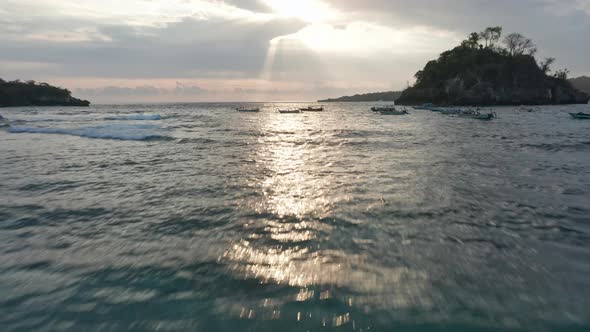 Aerial Tracking Shot of Beach, Sea Waters and Sunlight Reflecting on the Ocean alt