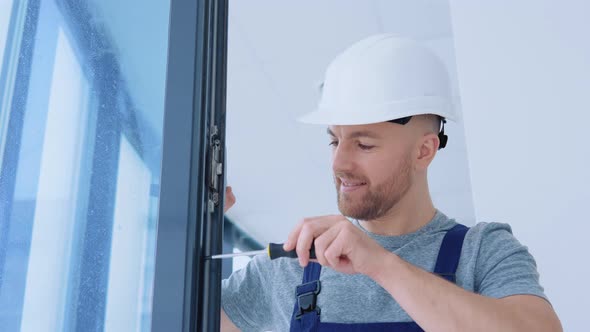 Serviceman Screwing a Window with a Screwdriver alt