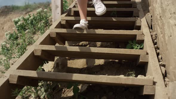 Slim Girl Legs Running Down Beach Staircase Wearing White Sneakers Close Up alt