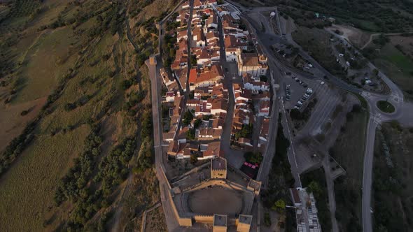Aerial top-down forward over Monsaraz village on hill at sunset, Portugal alt