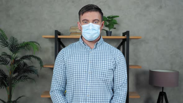 Businessman wears protective medical mask on face turns head looking camera alt