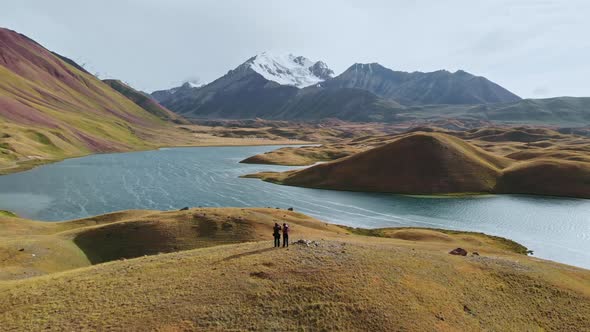 Aerial Shot of a Beautiful Valley with Surrounding Mountains Two People on Top of Hill alt