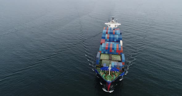 Aerial view of cargo container ship vessel import export container sailing. alt