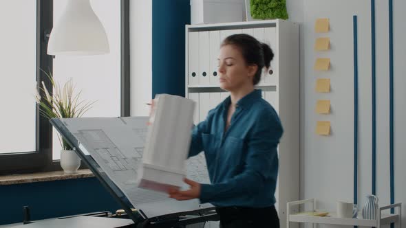 Close Up of Women Analyzing Building Model and Maquette Structure to Design Blueprints alt