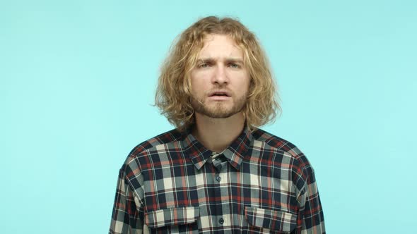 Slow Motion of Attractive Blond Man with Wavy Hair and Beard Looking Confused and Listening Then