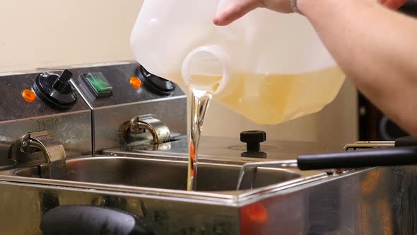 Cook Pouring Oil in Fryer