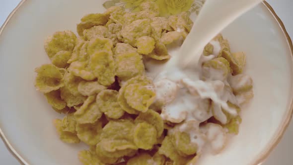 Yellow Corn Flakes Fall In A White Plate With A Pattern Of Flowers On The Edge 2