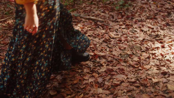 Woman's Legs Walking on the Dry Autumn Leaves and Twigs