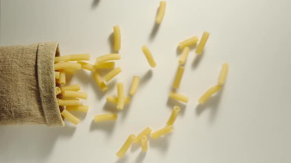 Bag Falls And Tortiglioni Are Poured Out Of It On White Background