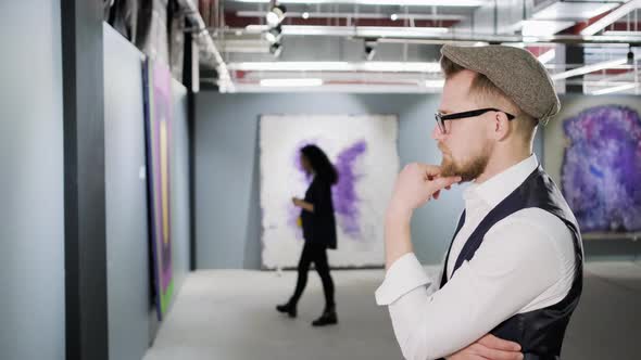 Man Examining the Canvas in Art Gallery alt